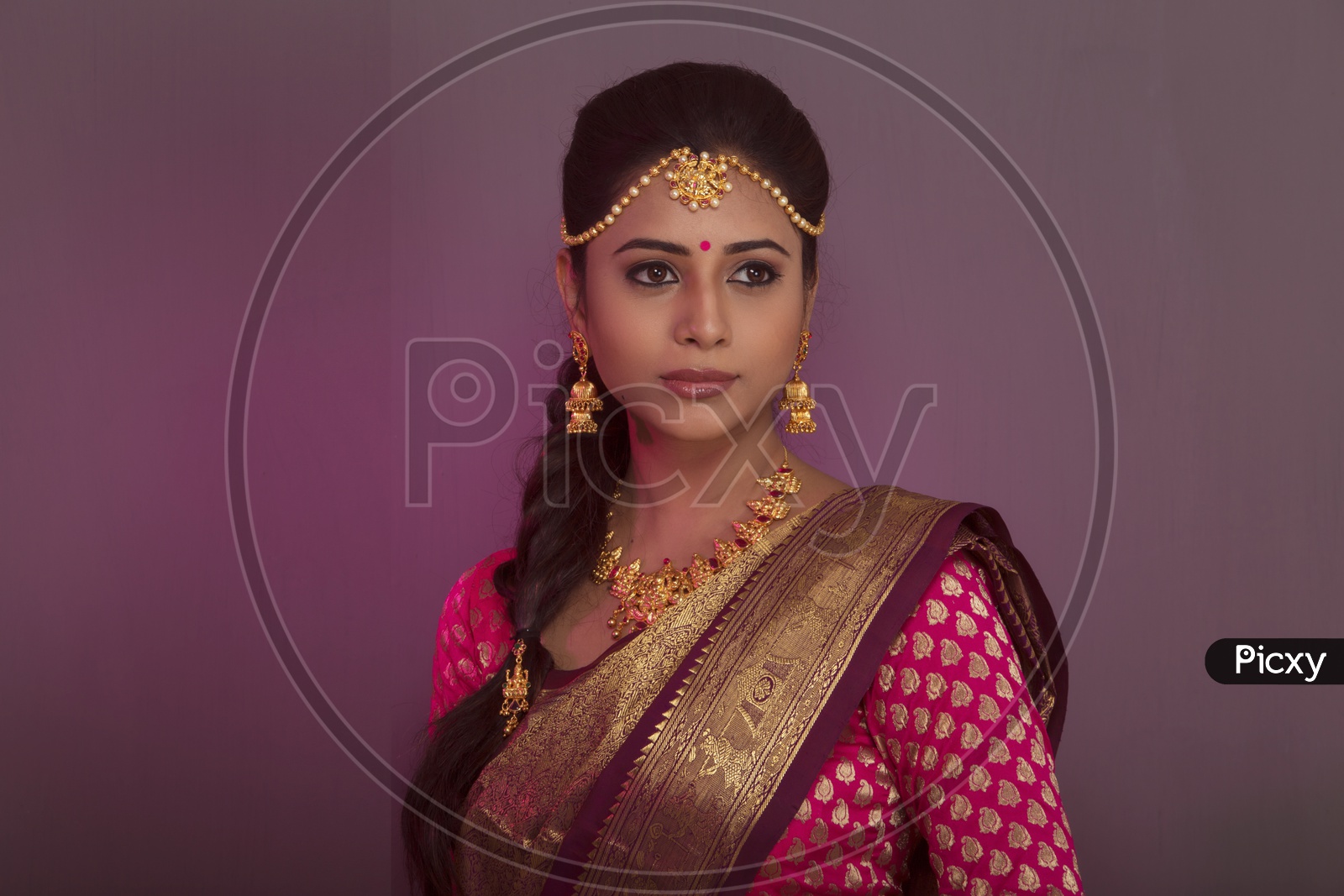 Indian bride dressed up in red saree portrait in Studio Lighting / Traditionally dressed up girl