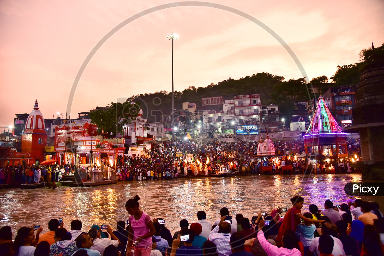 Indian Hindu Devotees at the Bank Of river ganges and Watching  the Holy Aarthi / Harathi in Haridwar /  Har ki Pauri Ghat