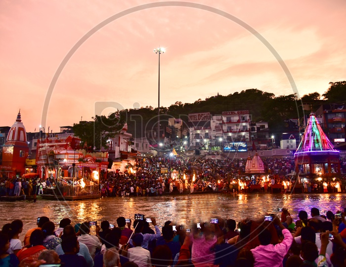 Indian Hindu Devotees at the Bank Of river ganges and Watching  the Holy Aarthi / Harathi in Haridwar /  Har ki Pauri Ghat