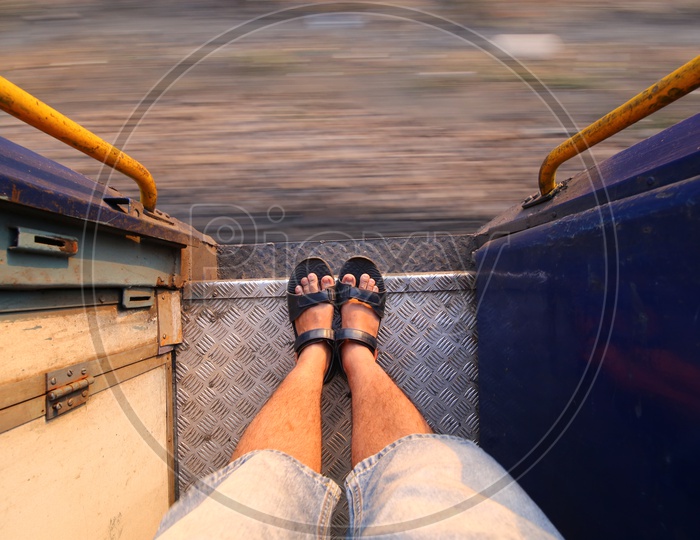 A Composition Shot of Man Foot Standing On Foot board of a Moving Train