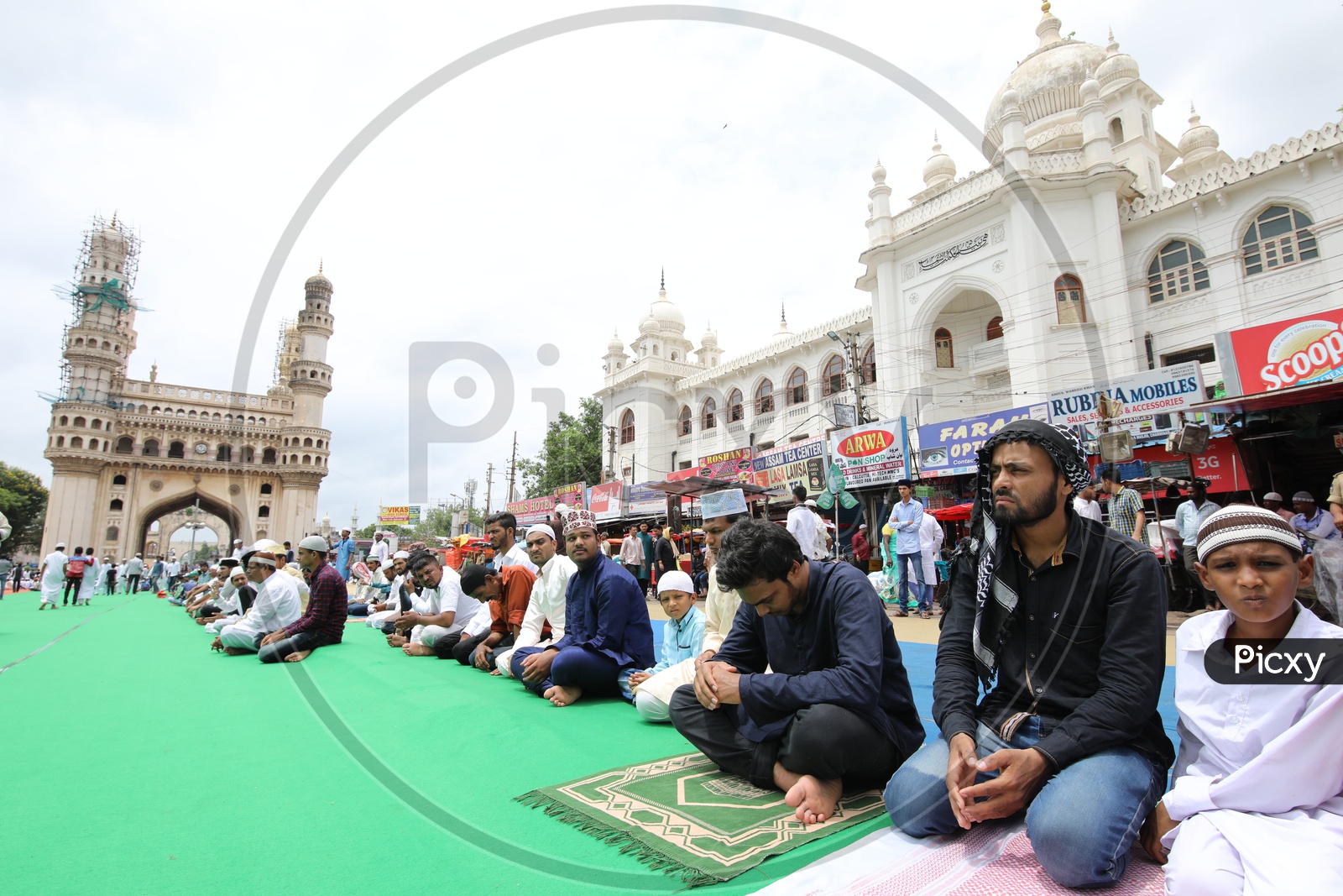 People doing namaz in charminar streets with charminar in the background