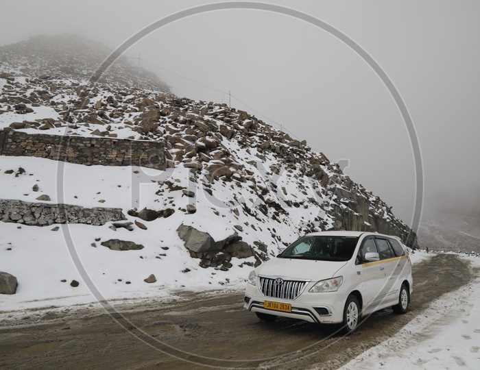 Vehicles Passing by The Roads in Leh With Snow filled mountains