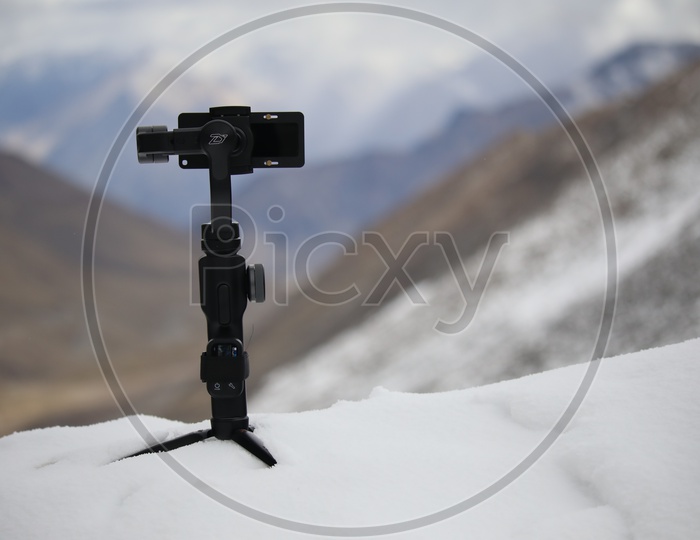 A monopod on the Snow To Which a Mobile Has mounted