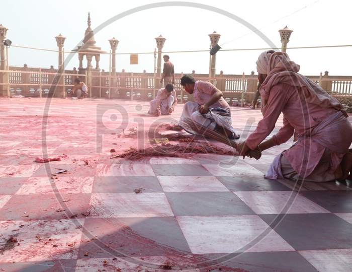 people cleaning floor after Holi celebrations