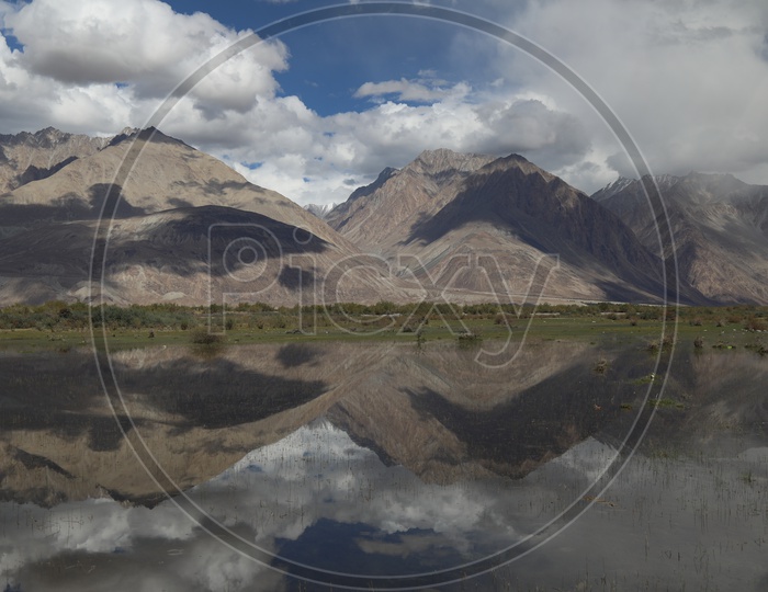 Landscapes of Leh mountains & Clouds, reflections of the same are seen in the lake