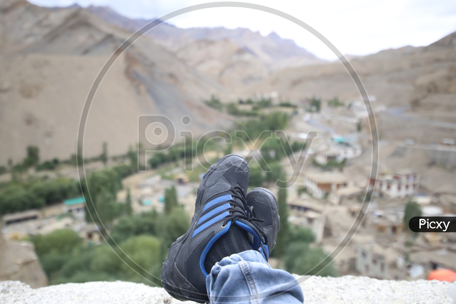 A Composition Shot Of Tourists With Their Legs and Valley Views In Leh