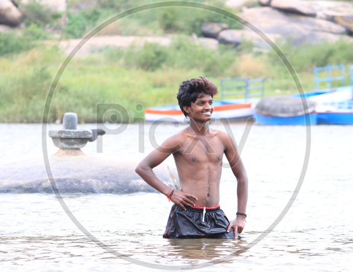 A boy posing in the river - Shivalingam in the background