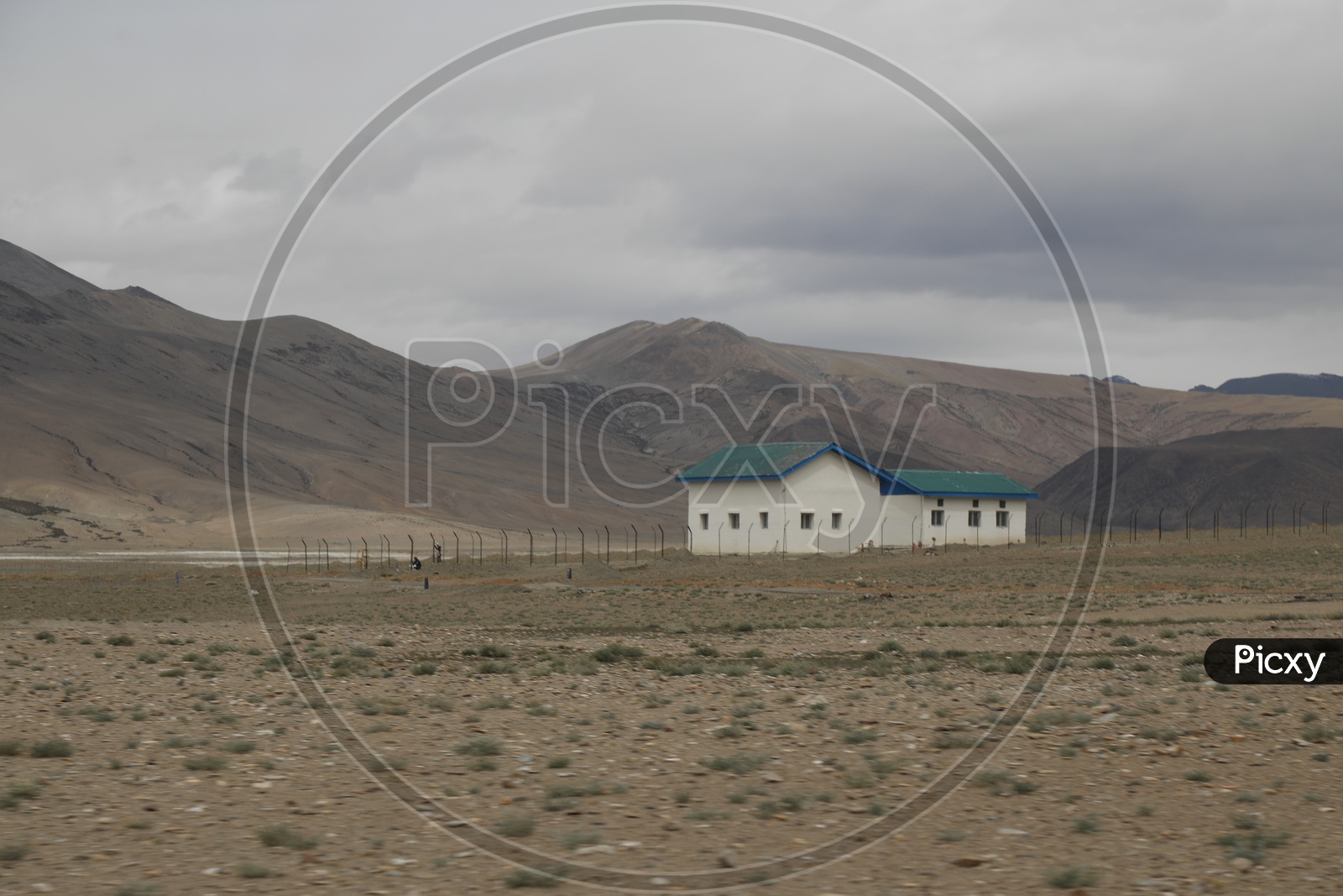 Beautiful Landscape of Snow Capped Mountains from Leh with a house in the foreground