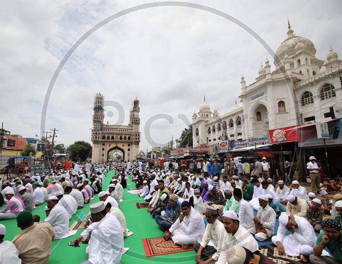 People doing namaz in charminar streets with charminar in the background