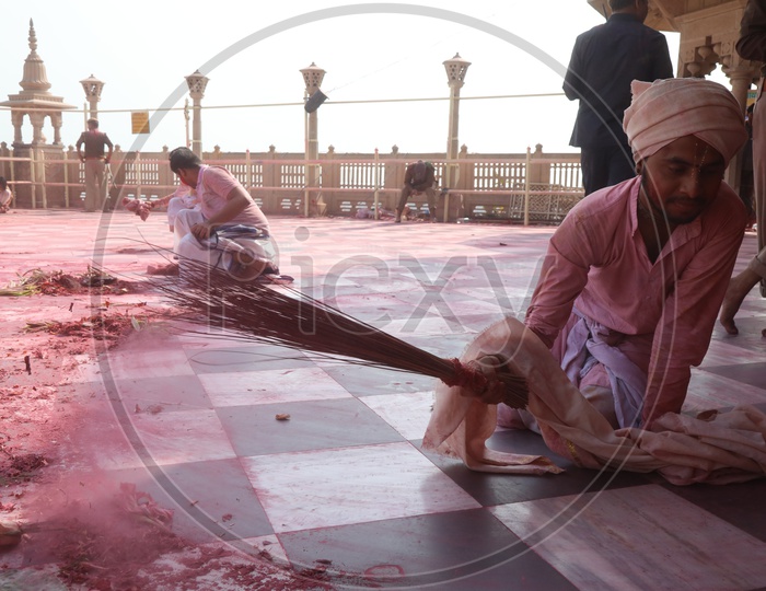 people cleaning floor after Holi celebrations