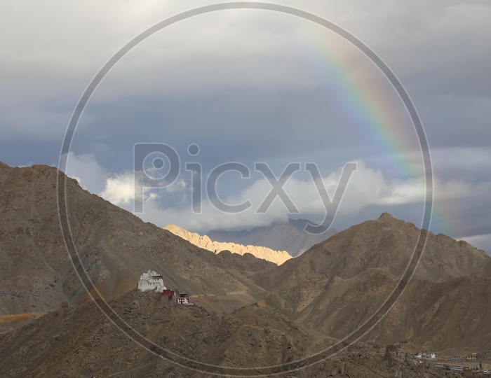 Snow Capped mountains of Leh with huge clouds and rainbow in sky