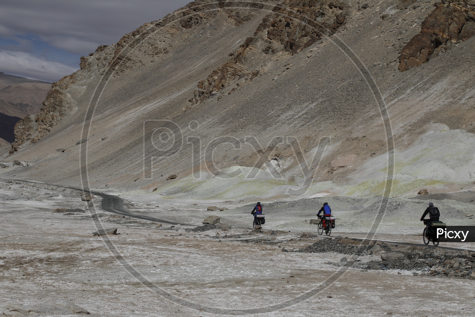 People Commuting by The Cycles On The Roads Of Leh With Sand Dunes in The Background