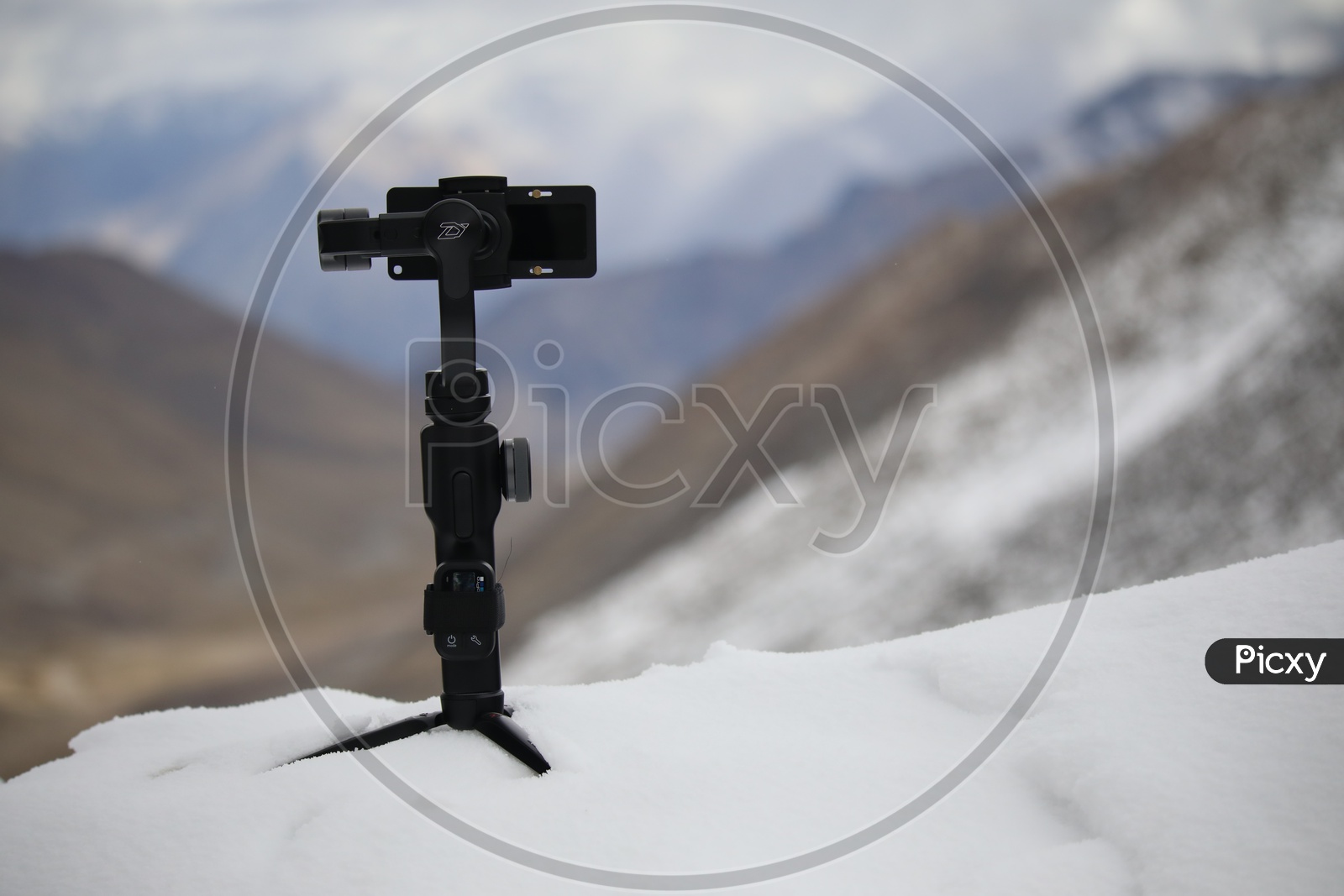 A monopod on the Snow To Which a Mobile Has mounted