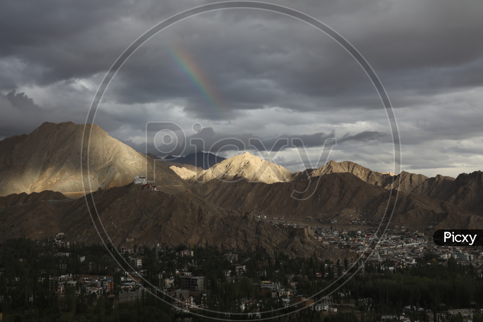 Snow Capped mountains of Leh with huge clouds and rainbow in sky