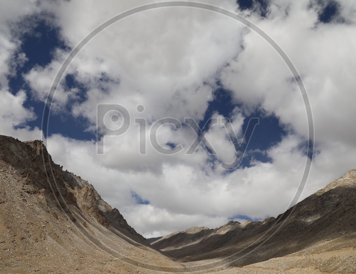 Beautiful Landscape of Snow Capped Mountains of Leh with huge clouds above mountains