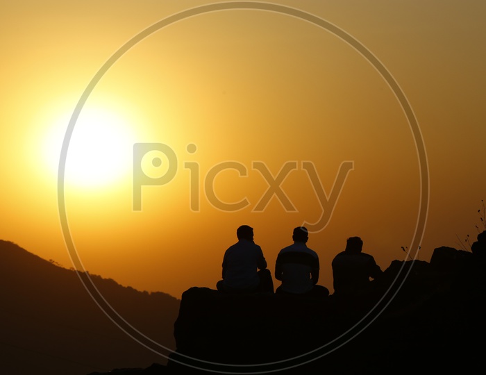 A Beautiful Silhouette of Three Friends sitting on  a hill  in Lonavala