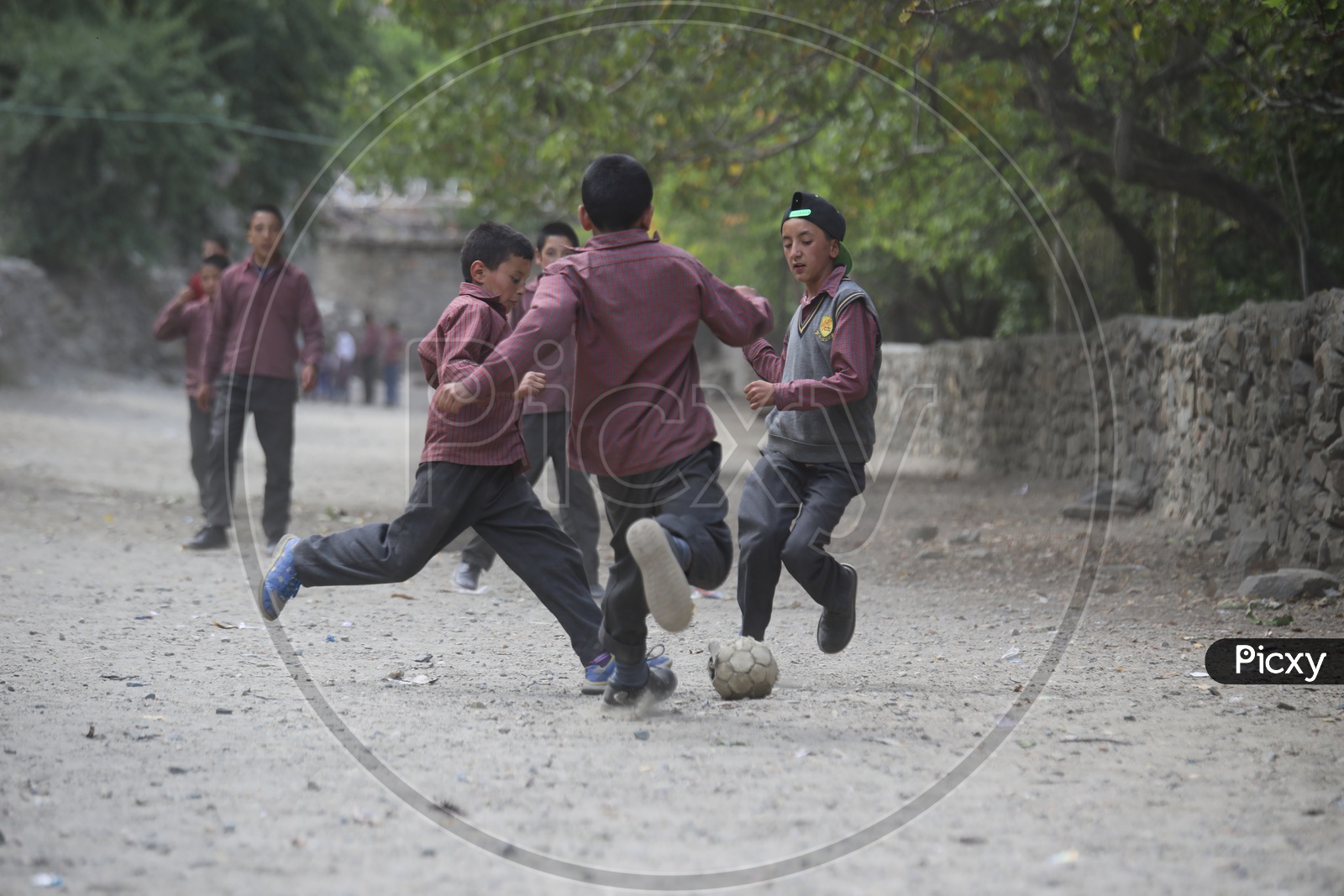 school kids playing football in leh