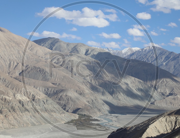 Beautiful Landscape of Snow Capped Mountains of Leh with clouds in sky