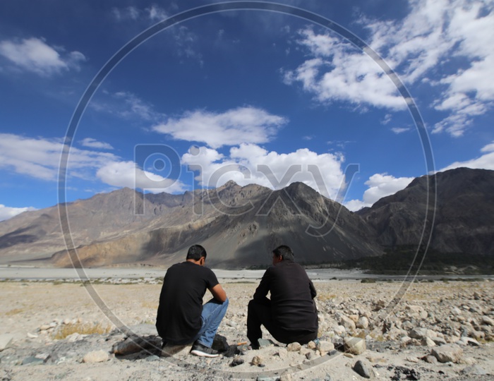 Travelers talking to each other in leh with beautiful snow capped mountains in the background