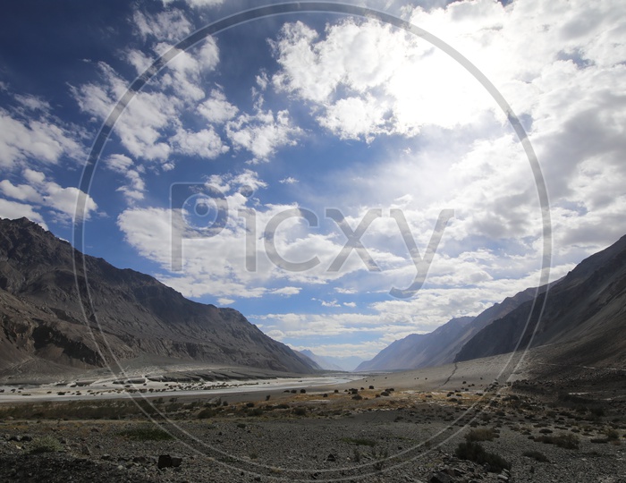 Beautiful Landscape of Snow Capped Mountains of Leh with  water flow in the foreground