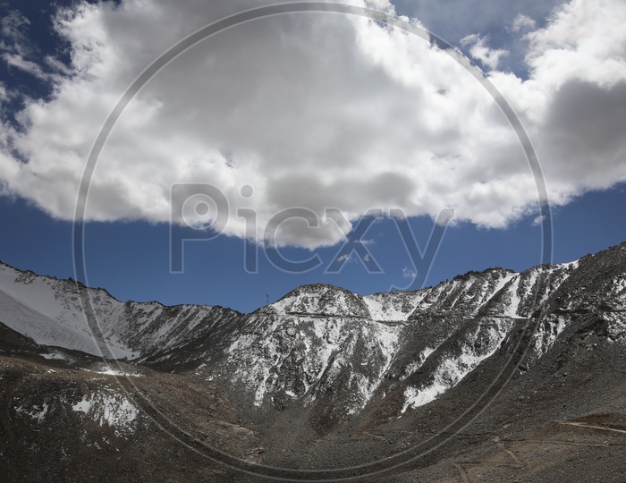 Beautiful Landscape of Snow Capped Mountains of Leh with clouds above the Mountains