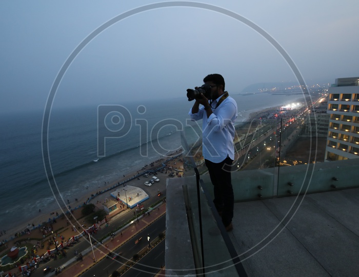 A Photographer Taking Pictures From Top Of The Novotel Hotel