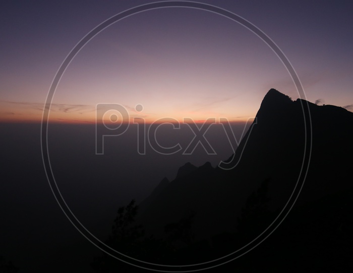 A Beautiful Silhouette Of Hills in Munnar Over a Sunset