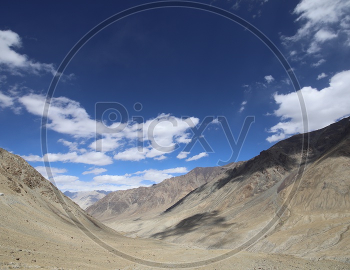Beautiful Landscape of Snow Capped Mountains of Leh with clouds above the Mountains