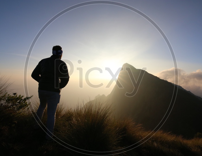 A Silhouette Of a Tourist Over a Beautiful Sunset on Hill Tops Of Munnar
