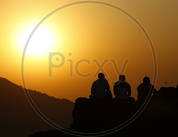 A Beautiful Silhouette of Three Friends sitting on  a hill  in Lonavala