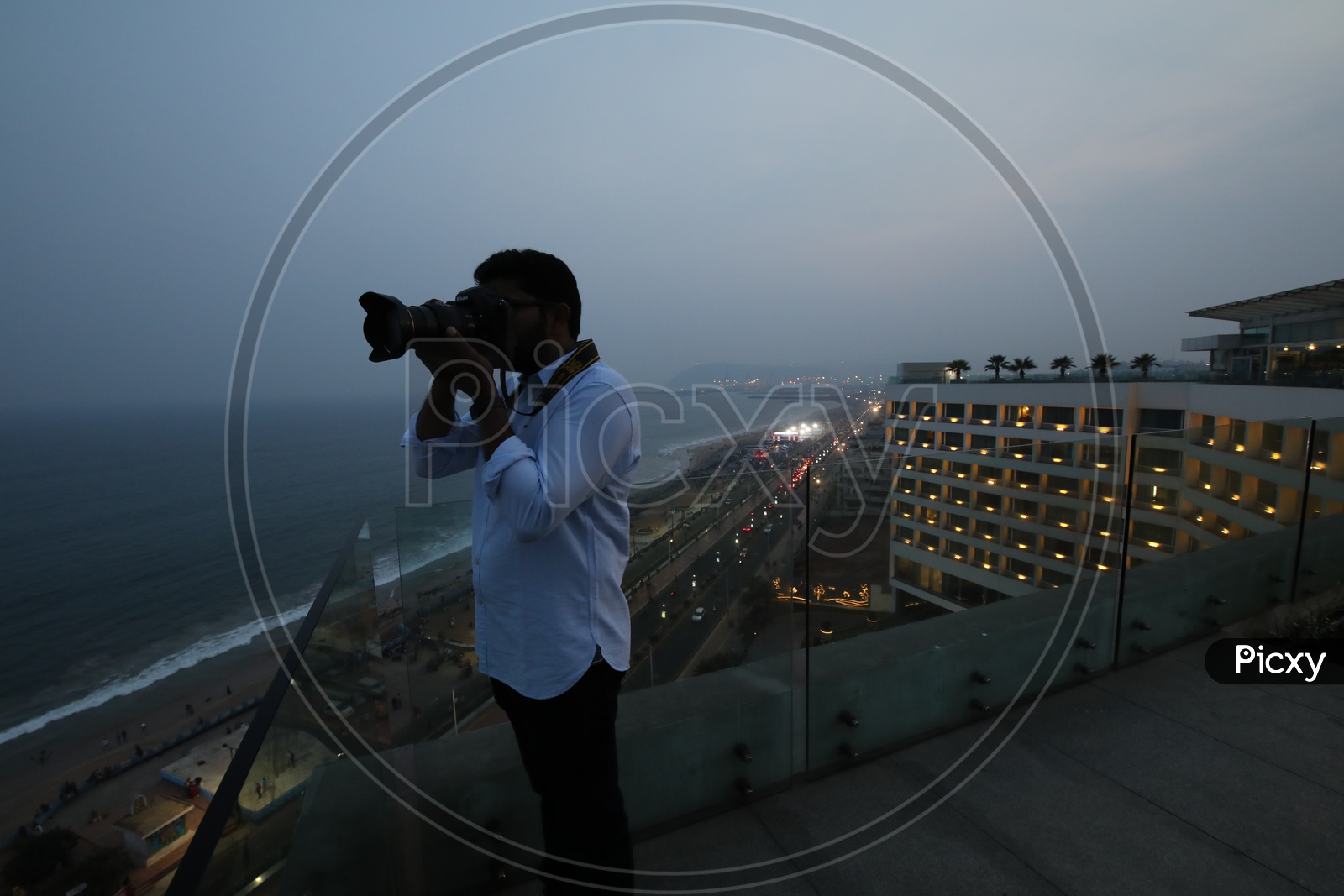 A Photographer Taking Pictures From Top Of The Novotel Hotel
