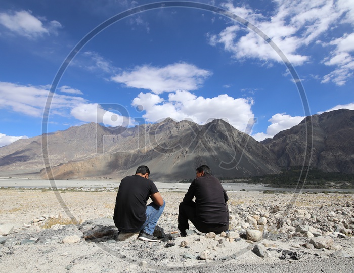 Travelers talking to each other in leh with beautiful snow capped mountains in the background