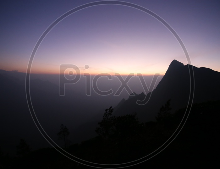 A Beautiful Silhouette Of Hills in Munnar Over a Sunset