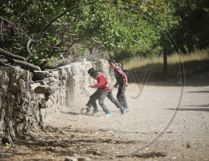 school kids playing football in leh
