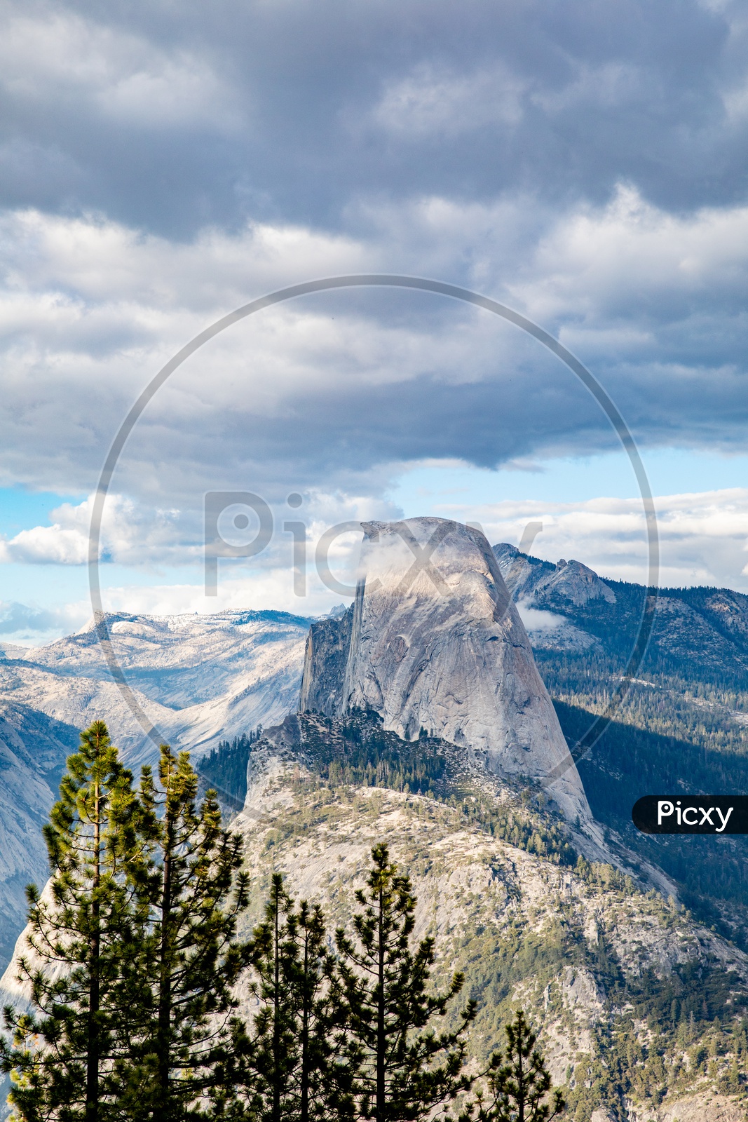 A Beautiful Mountain  Valley With Snow Capped Mountains and Blue Sky With  Clouds In Background