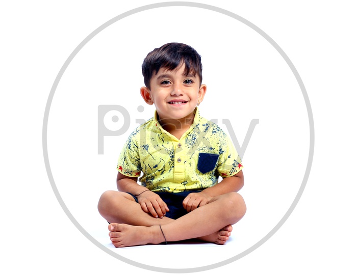 Indian Boy Sitting and Smiling in An Isolated white Background