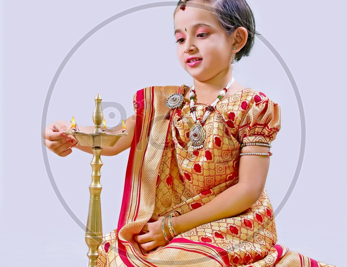 Indian Girl Child lighting Diya in Traditional Dress for Festival
