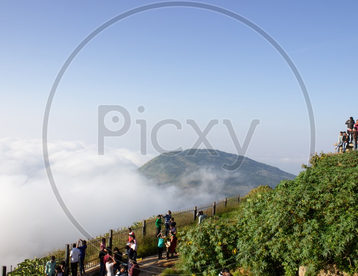 Beautiful View Point at Nandi hills with Clouds and Mountains / People Exploring Nandi Hills