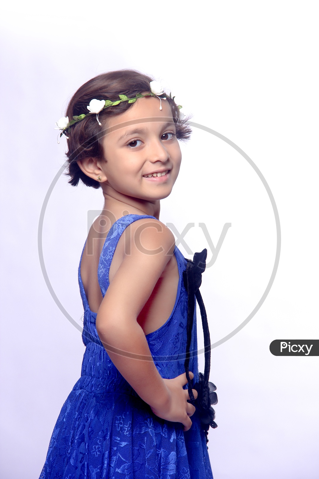 Girl dressed up in blue frock with a flower hair band