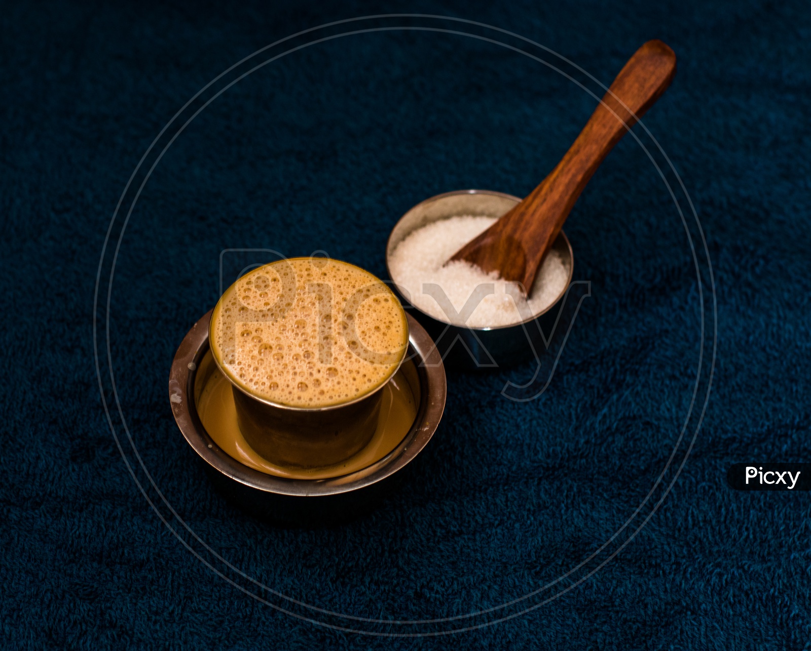 South Indian / Madras Filter Coffee  with a Sugar Bowl Besides on a Dark Blue background