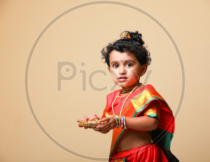 Indian girl dressed in Saree as a Marathi Woman Rani and taking Aarathi/Arati
