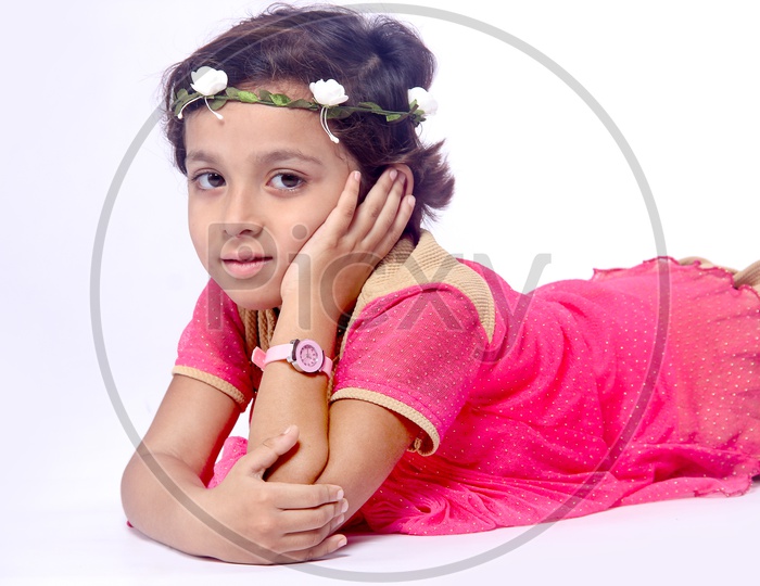 Girl dressed up in pink frock with a flower hair band