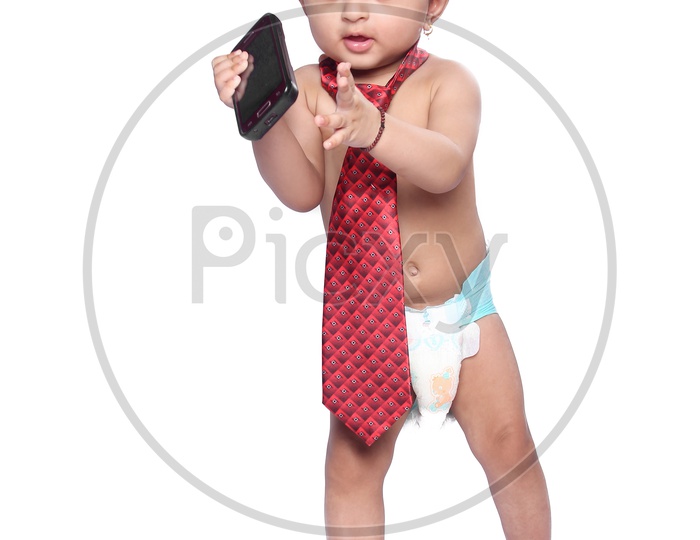 Baby girl wearing a tie, holding mobile phone