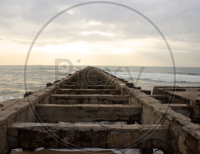A Pier Closeup Shot Leading To Sea with Structures of Pillars