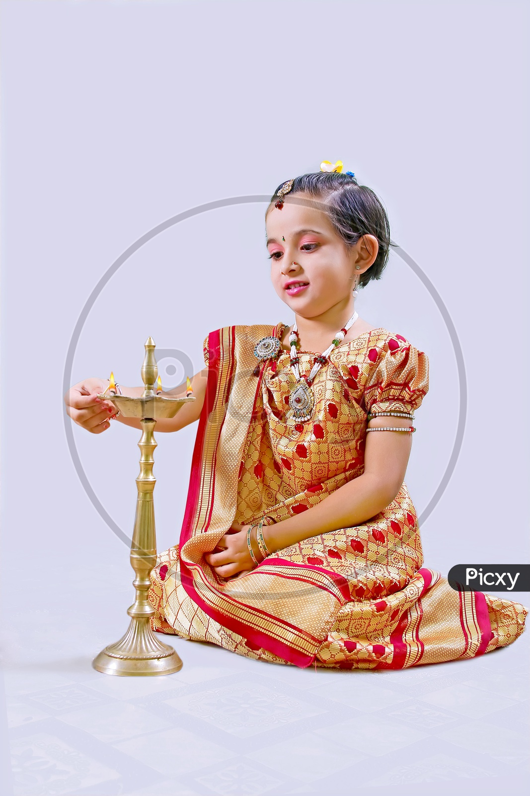 Indian Girl Child lighting Diya in Traditional Dress for Festival