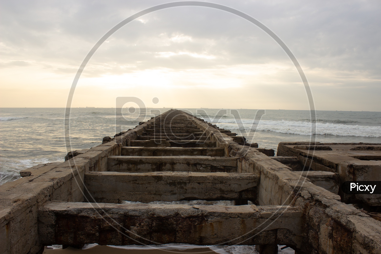 A Pier Closeup Shot Leading To Sea with Structures of Pillars