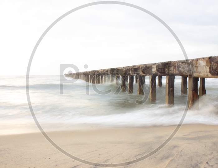 Long Exposure Shot of a Pier and Sea Waves  From Shore