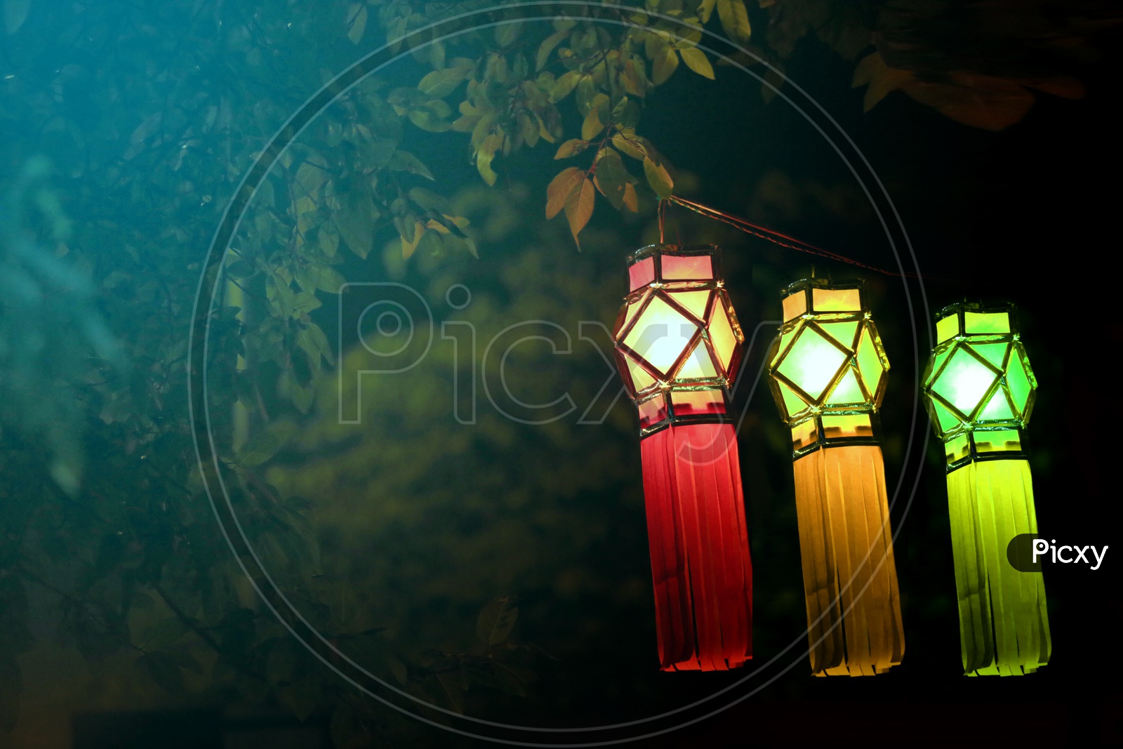Three glowing and hanging lanterns with a dark background