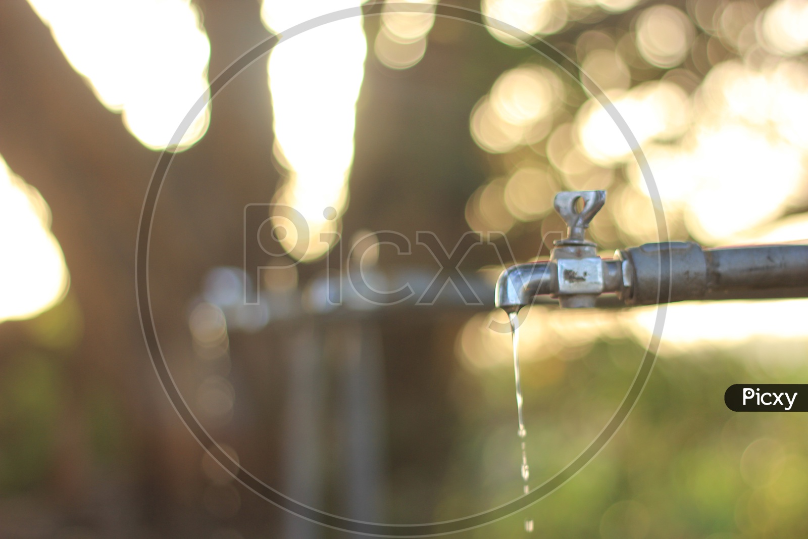 Water leakage from tap with beautiful bokeh in the background / Water drops