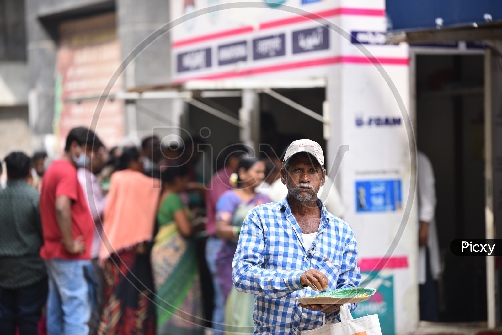 An Old Man Posing to camera while having meals brought from GHMC Annapurna Meal Counter.
